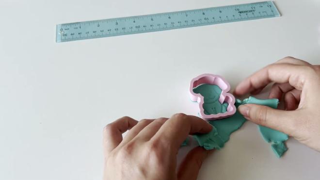 Using the dog cookie cutter and embossing stamp in fondant