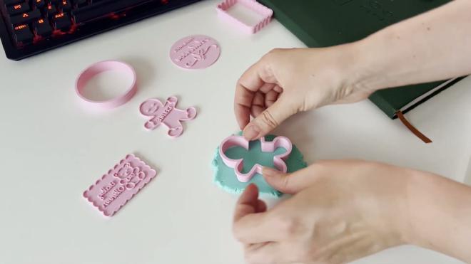 Pressing a 3D printed gingerbread stamp cookie cutter into blue fondant