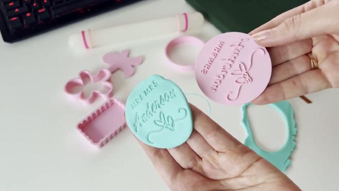 Pink wedding stamp cookie cutter next to blue fondant embossed with MR and MRS Anderson